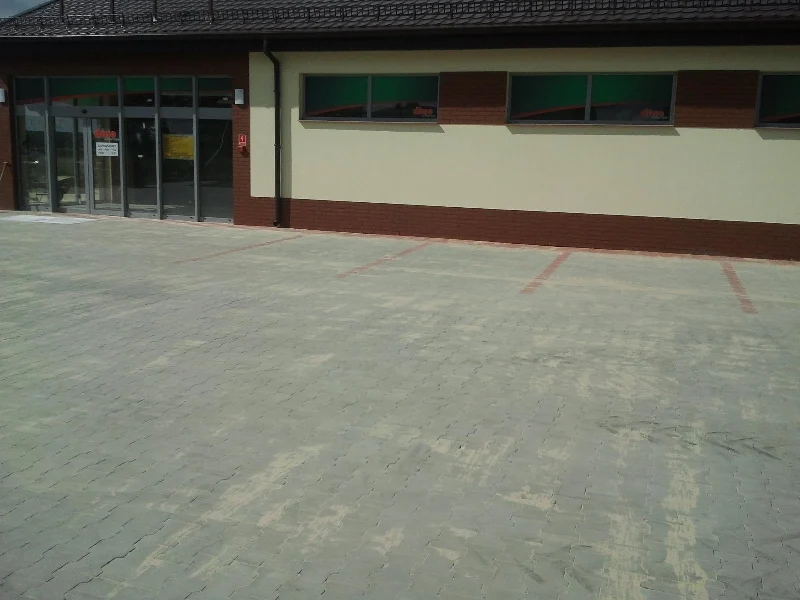 Rozległy plac wyłożony kostką brukową przy budynku